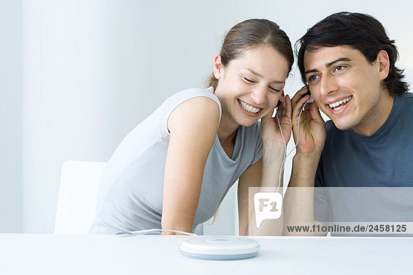 Paare  die zusammen CD-Player hören  Kopfhörer teilen  lächeln
