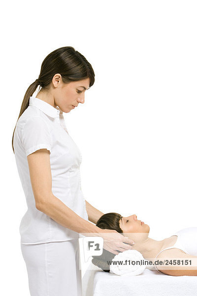 Massage-Therapeutin mit Kopfmassage  Seitenansicht