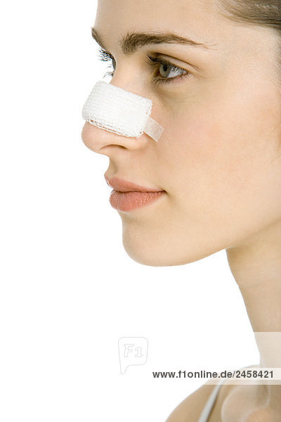 Junge Frau mit bandagierter Nase  Profil  abgeschnitten