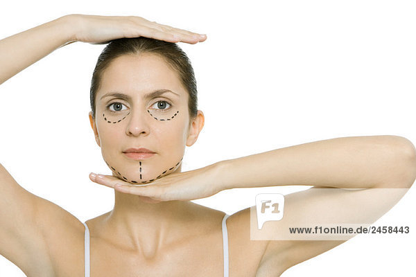 Frau mit plastischen Operationsmarkierungen im Gesicht  Rahmenkopf mit Händen  Blick auf Kamera