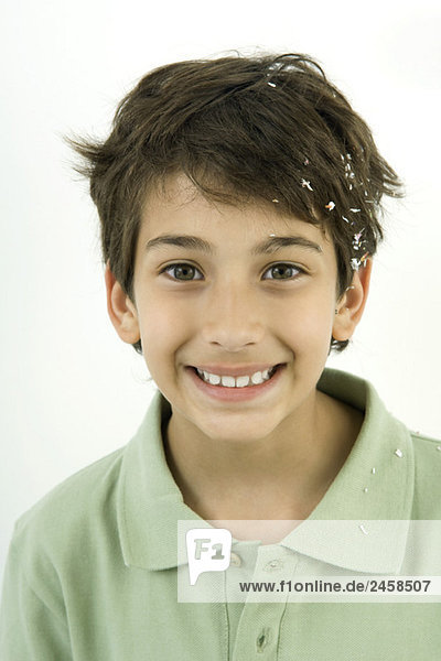 Boy with confetti in his hair  smiling  portrait
