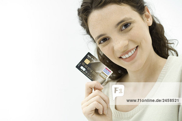 Frau mit Kreditkarte  lächelnd vor der Kamera