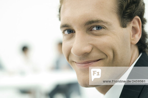 Man smiling over shoulder at camera  close-up