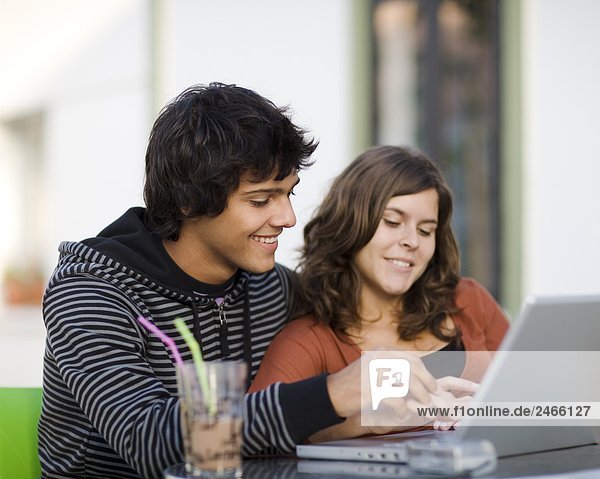 Junges paar bei einem Caf mit einem Laptop Portugal.