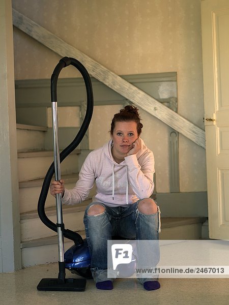 A young Scandinavian woman with a vacuum cleaner Sweden.