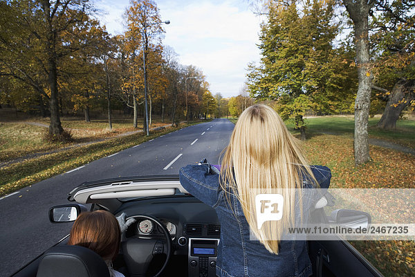 Two young women driving a cabriolet an autumn day Sweden.