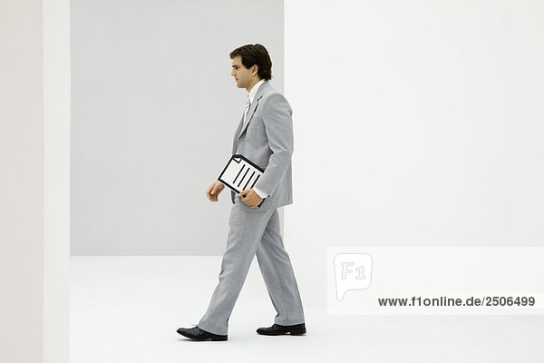 Businessman carrying document  side view