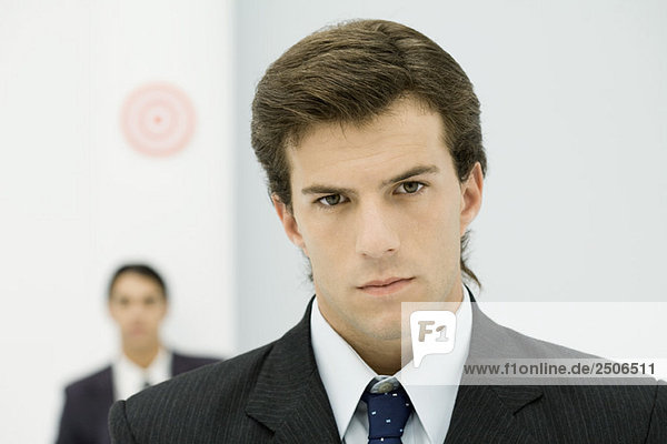 Young businessman frowning at camera  close-up