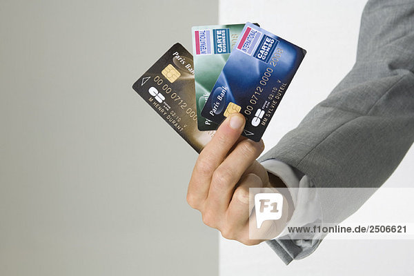 Geschäftsmannhand mit mehreren Kreditkarten,  abgeschnittene Ansicht