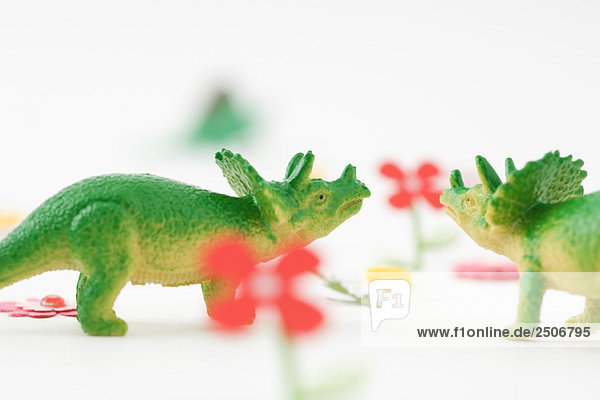 Spielzeug-Triceratops von Angesicht zu Angesicht im künstlichen Garten