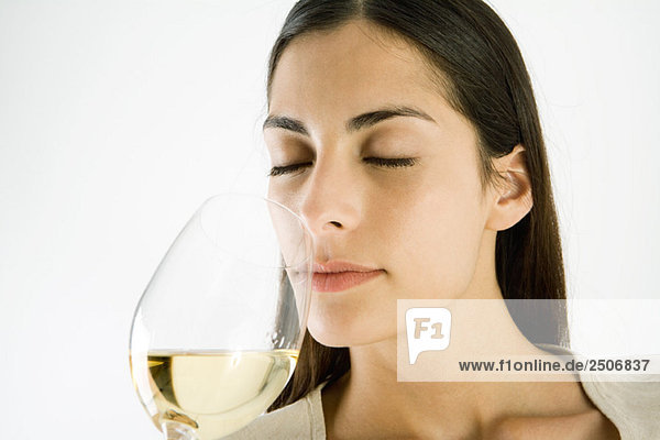 Frau riecht ein Glas Weißwein  Augen geschlossen