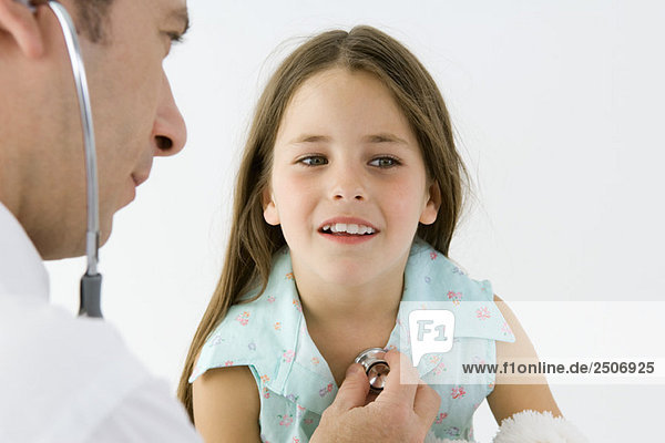 Kinderarzt beim Hören des Mädchenherzens mit Stethoskop