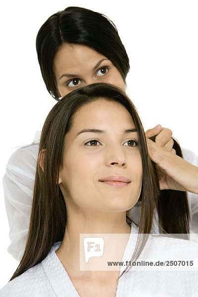 Friseurin  die das Haar der Frau fixiert.