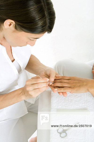 Kosmetikerin mit Maniküre  abgeschnittener Blick auf die Hand der Frau  hoher Blickwinkel