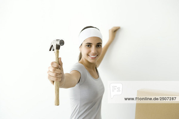 Teen girl showing hammer to the camera  smiling