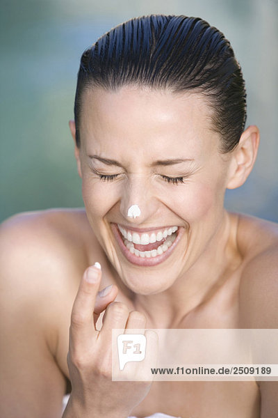 Junge Frau mit Gesichtscreme  Portrait  Lachen  Portrait