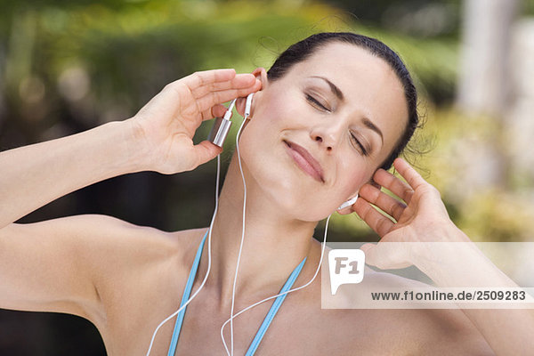 Junge Frau hört MP3-Player  Augen zu  Portrait