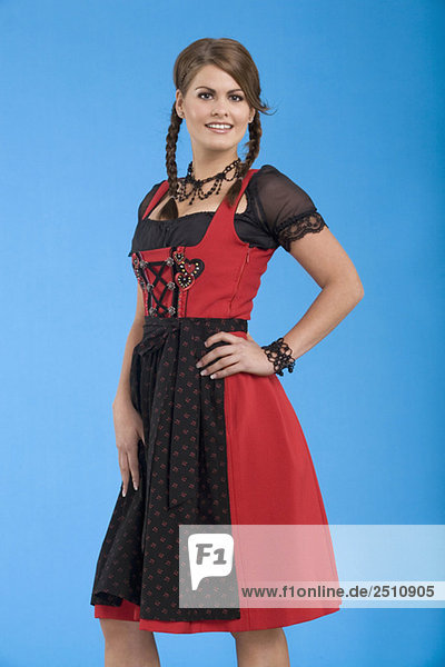 Young woman in traditional costume  hand on hip  smiling  portrait