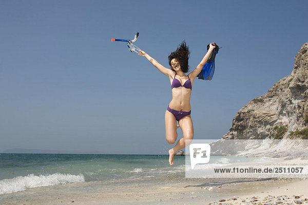 Asia  Thailand  Young woman jumping on beach