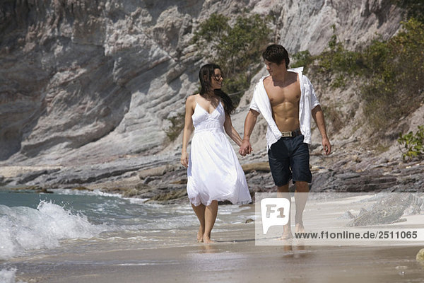 Asien  Thailand  Junges Paar geht Hand in Hand am Strand entlang