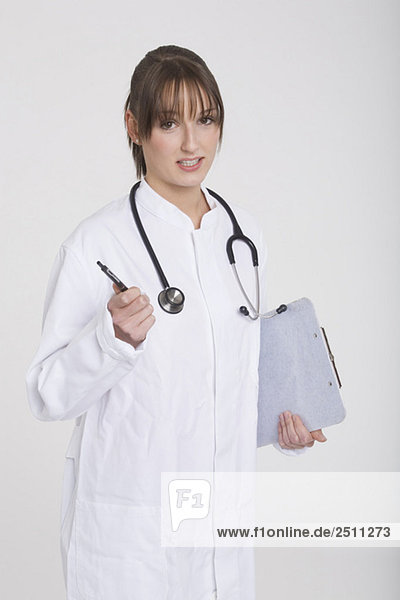 Young woman with stethoscope and dipboard