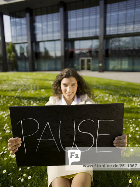 Business woman taking a break  holding sign