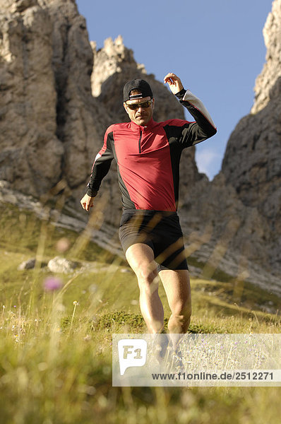 Mid adult man running on landscape  Trentino-Alto Adige  Italy