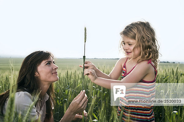 Frau und Kind halten Weizen.