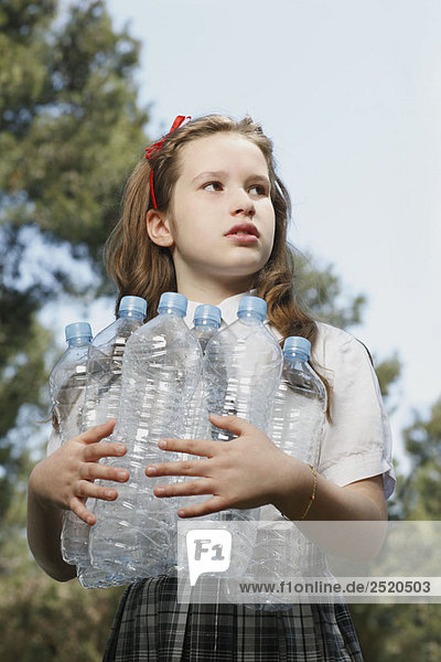 Young girl holding empty bottles