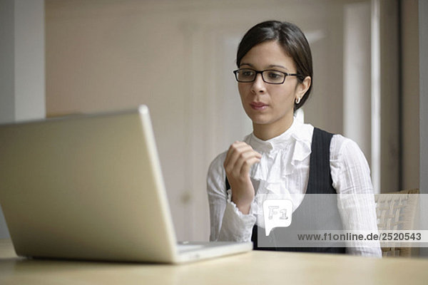 Geschäftsfrau sitzend mit Laptop