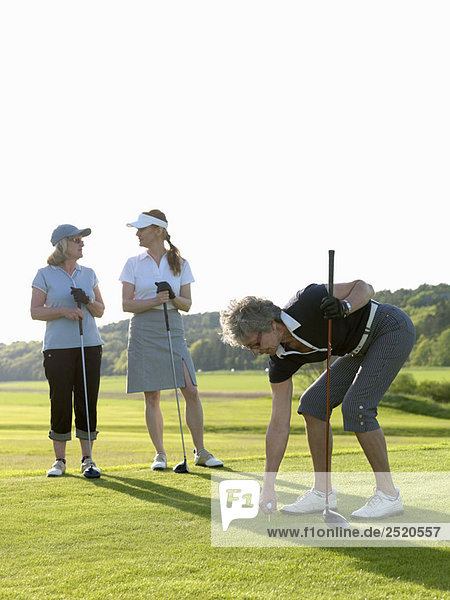 Drei Golferinnen am Abschlag