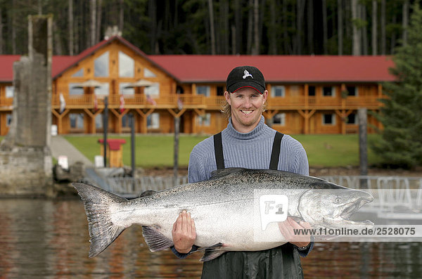 Fisherman displays his 71lb Chinook  Queen Charlotte Islands  British Columbia.