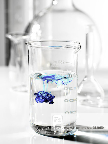 Blaue Flüssigkeit in ein Becherglas mit Wasser