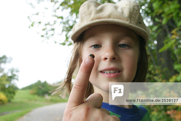 Girl Looking at Ladybug on Finger
