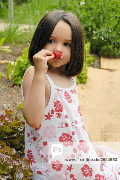 Junges Mädchen riechen einer Erdbeere