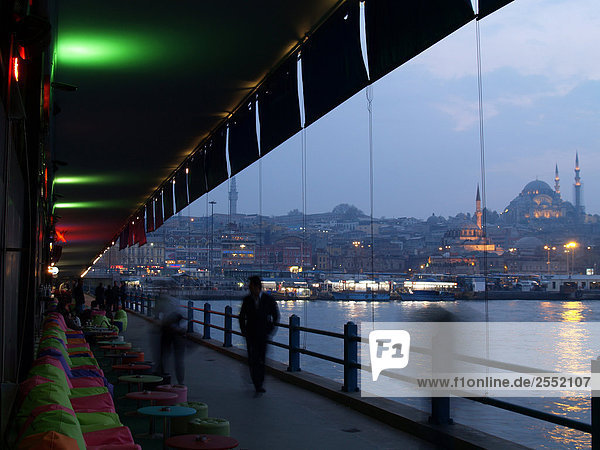 Silhouette of people walking in front of restaurant  Galata Bridge  Golden Horn  Istanbul  Turkey
