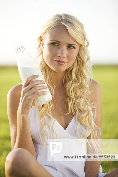 Young woman holding a milk bottle