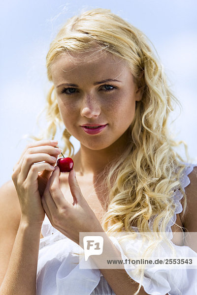 Portrait of young woman with cherries