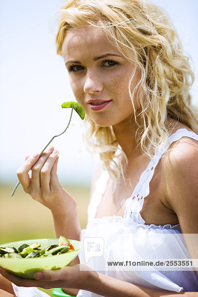 Junge Frau isst Gemüse