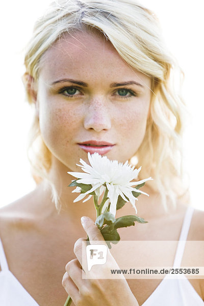 Porträt einer jungen Frau mit weißer Blume