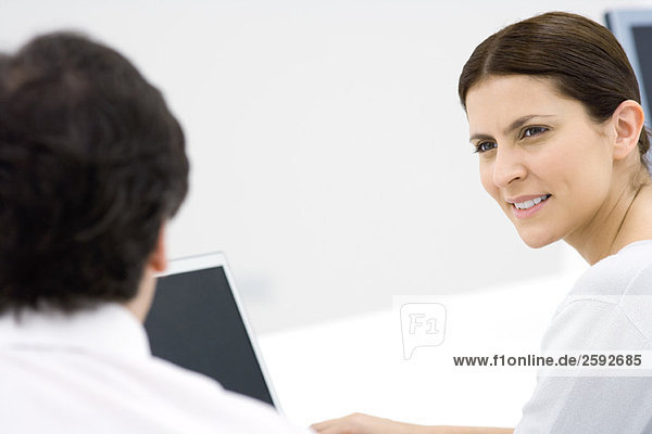Professional woman seated  looking at male colleague  cropped
