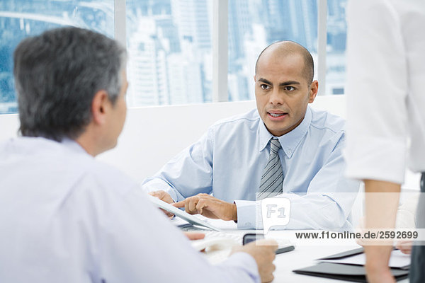 Businessmen having a meeting at desk  focus on man in background