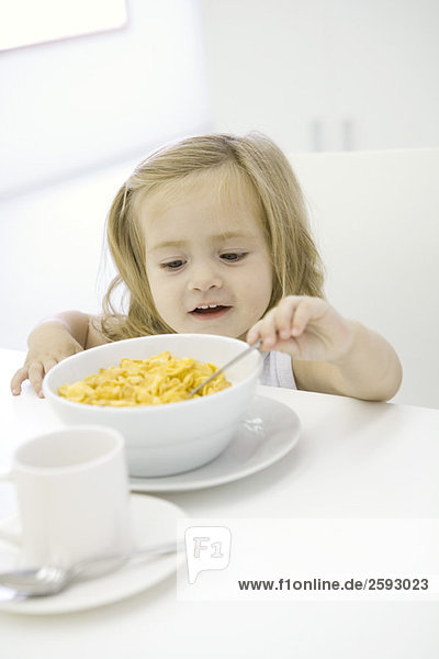 Kleinkind Mädchen erreicht zu essen Schüssel mit Getreide