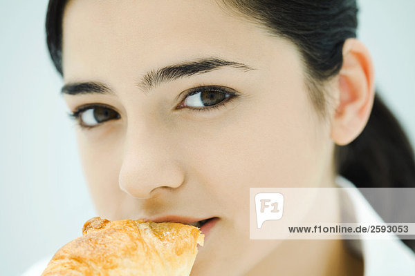 Junge Frau beim Croissantessen  Nahaufnahme
