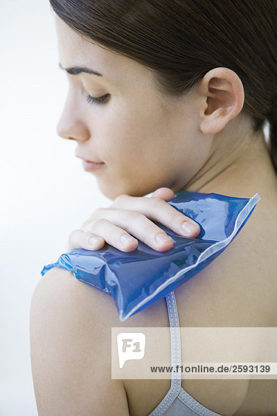 Woman placing cold compress on shoulder  close-up
