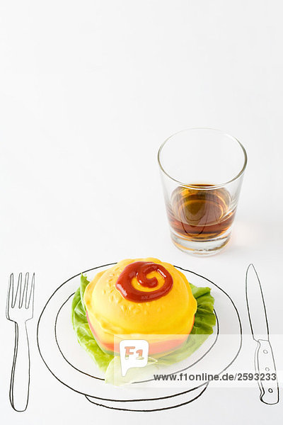 Ketchup und Plastik-Hamburger auf Tellerzeichnung  Glas Whisky in der Nähe