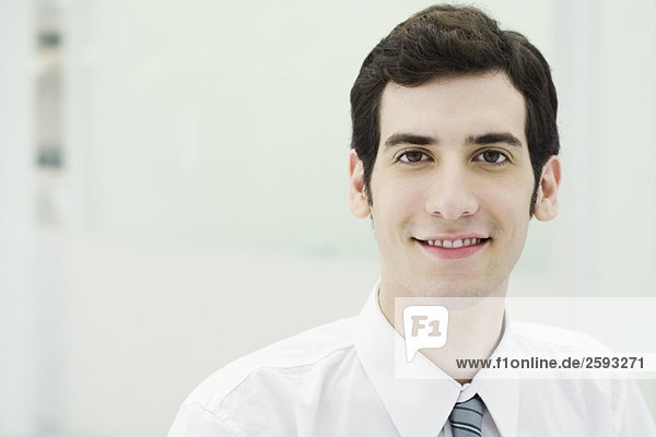 Junger Geschäftsmann lächelt vor der Kamera  Porträt