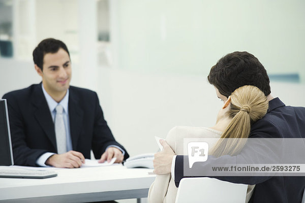 Meeting between professional and clients  woman resting head on man's shoulder