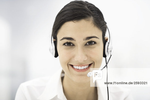 Woman wearing headset  smiling at camera  portrait