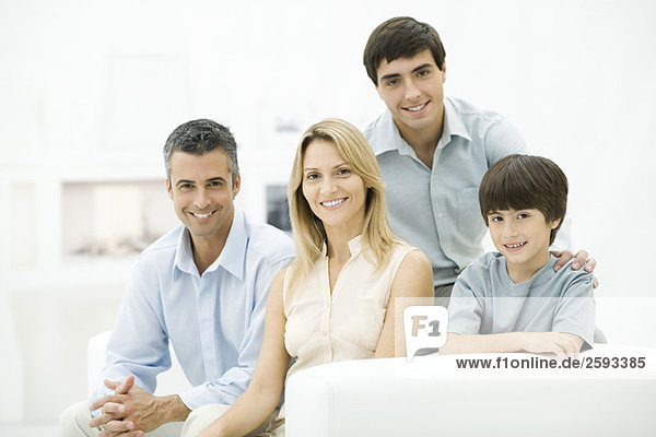 Family sitting together on couch  smiling  portrait